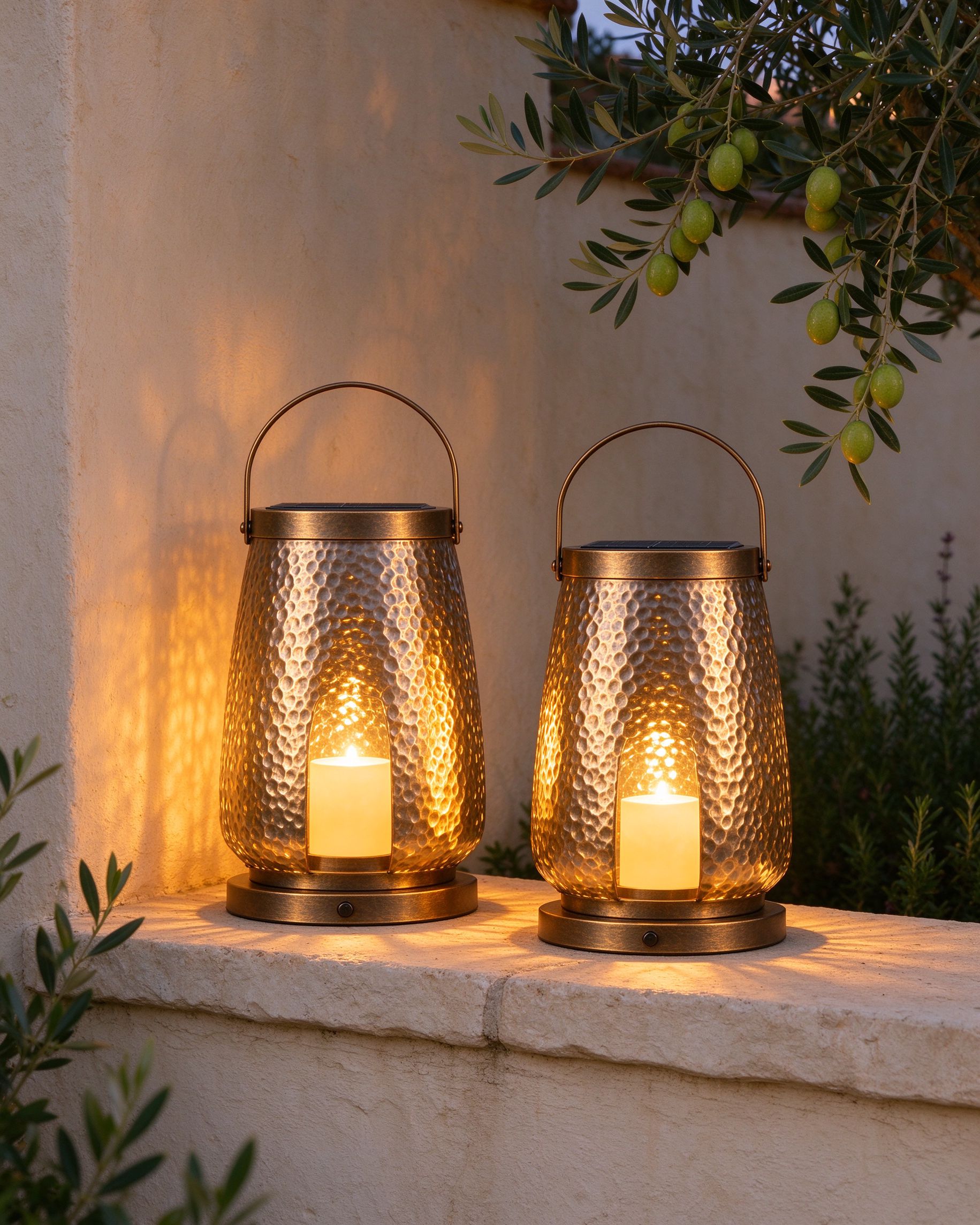 Two hammered-metal solar garden lanterns glowing at dusk