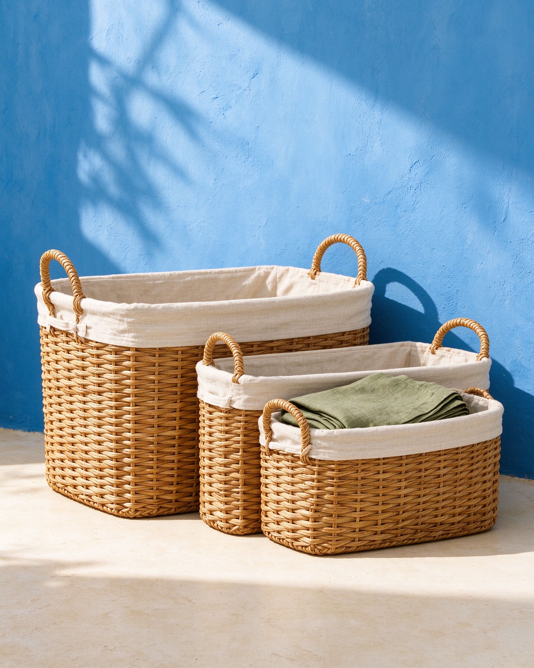 Set of three woven rattan storage baskets with linen liners